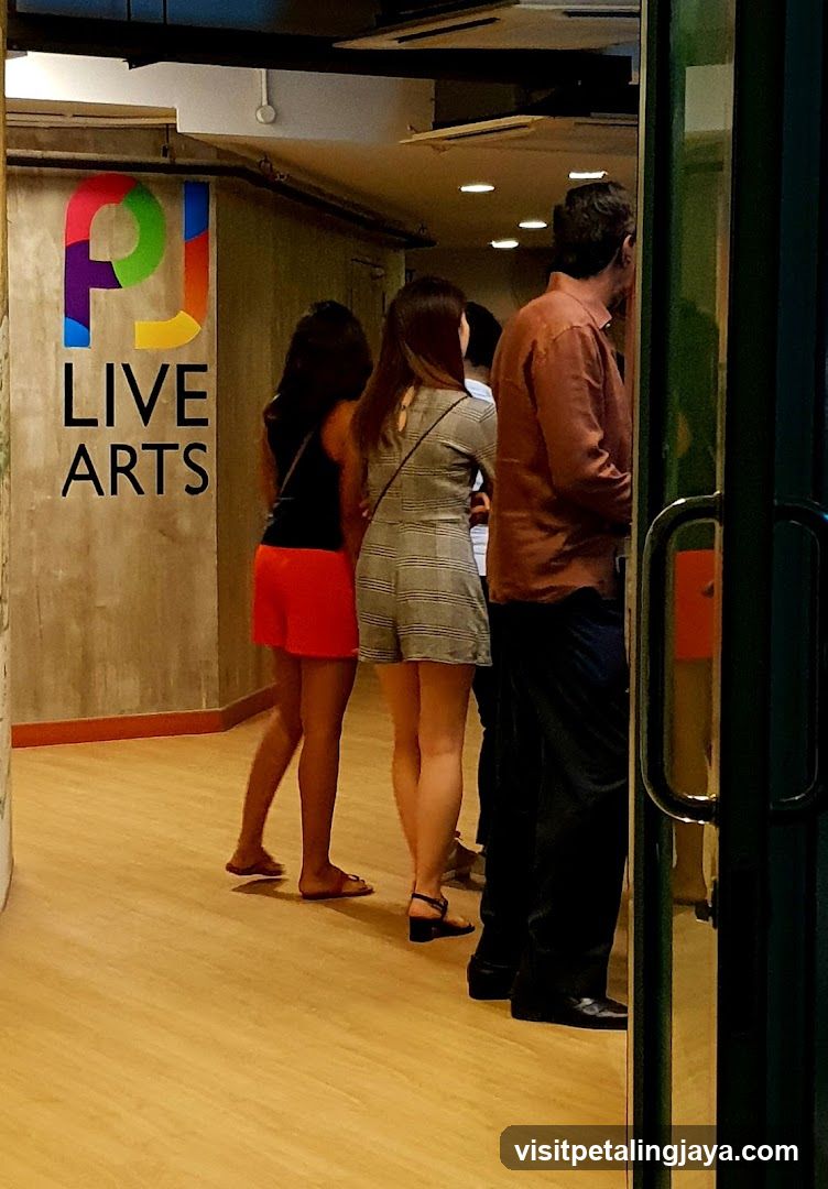 People in a hallway with Live Arts sign