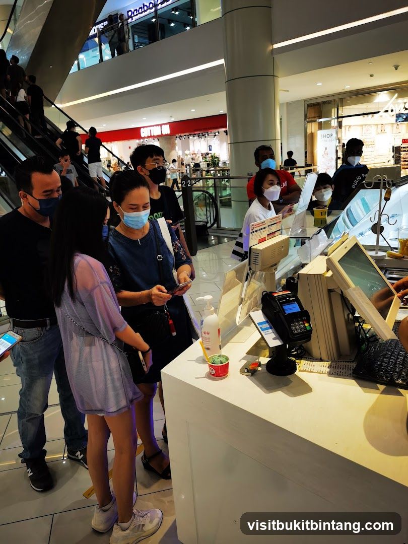 People queuing at a counter in a mall
