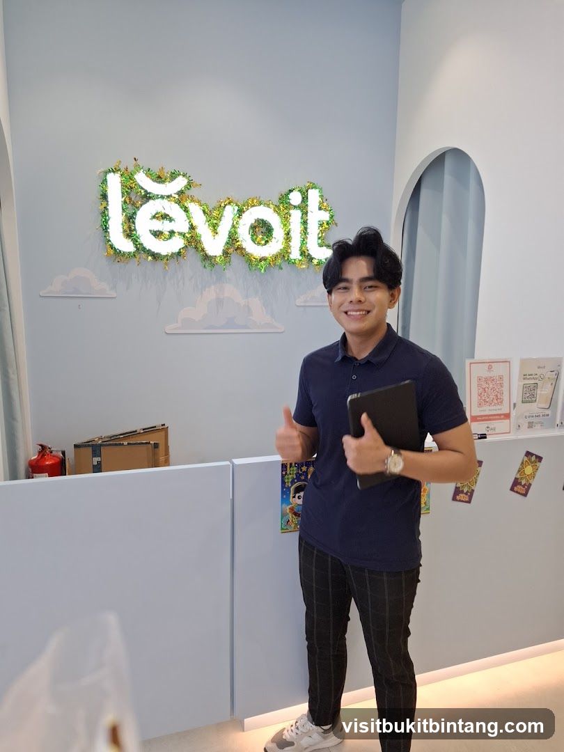 Man giving a thumbs up in front of a Levoit sign