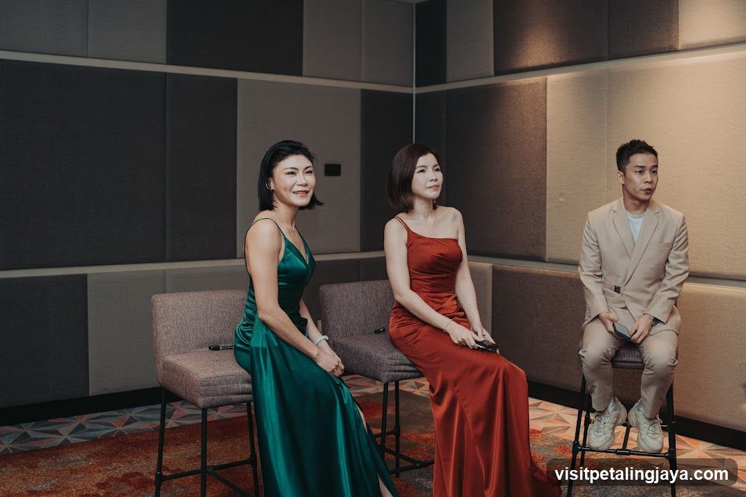 Three people in formal attire sitting indoors