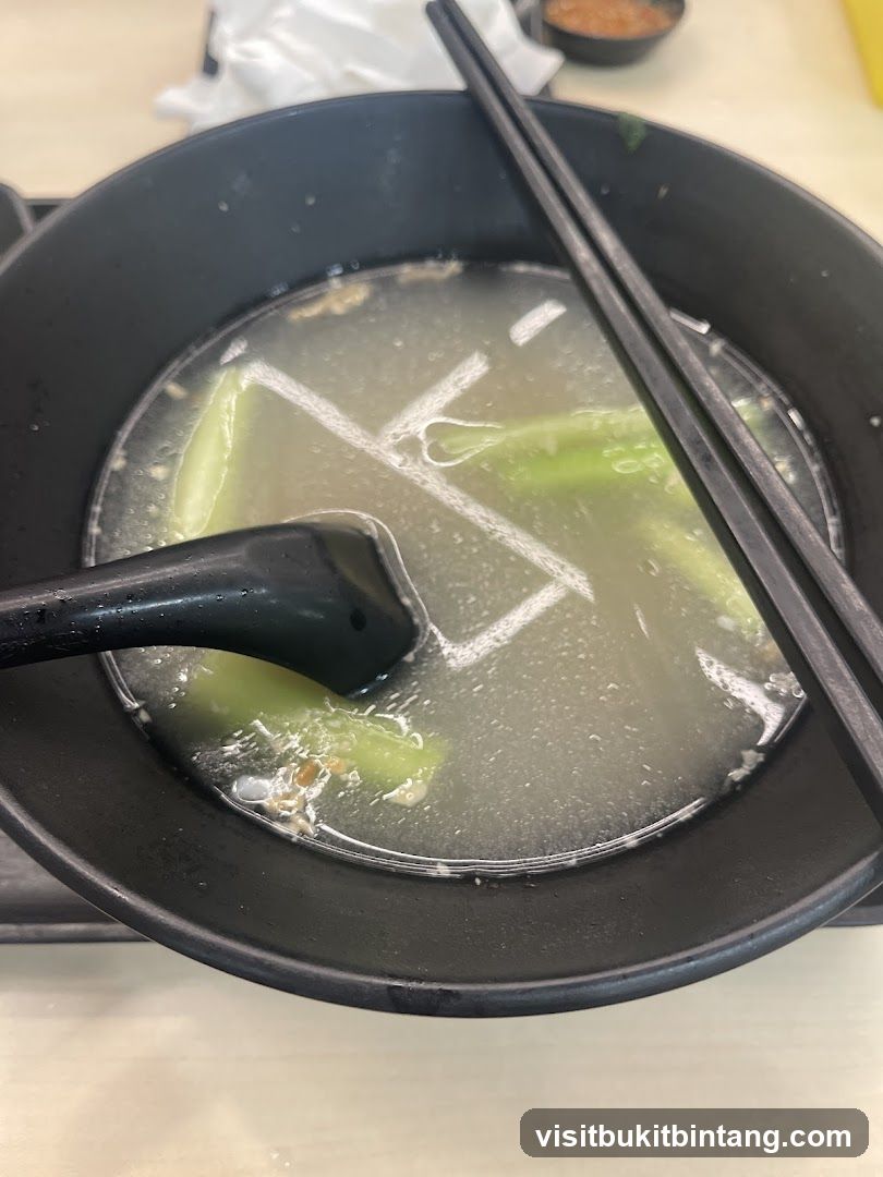 Bowl of Soup with Vegetables and Chopsticks
