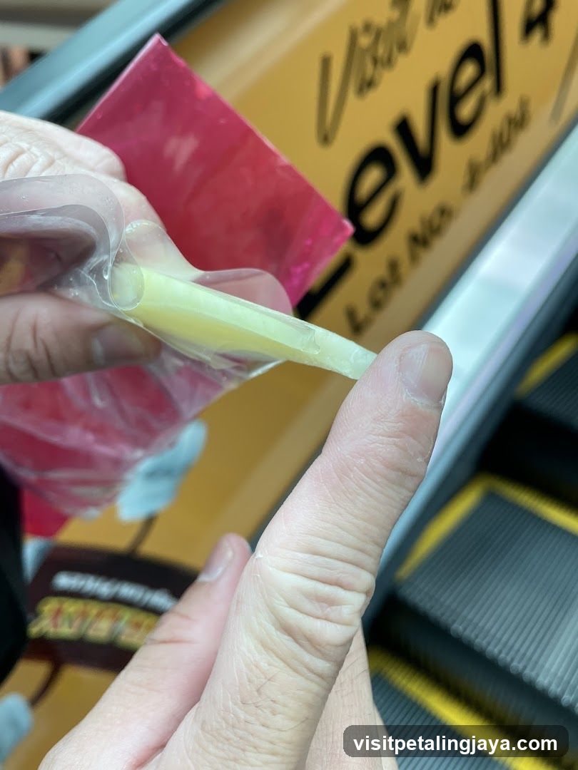 Hand holding a packaged food item near escalator