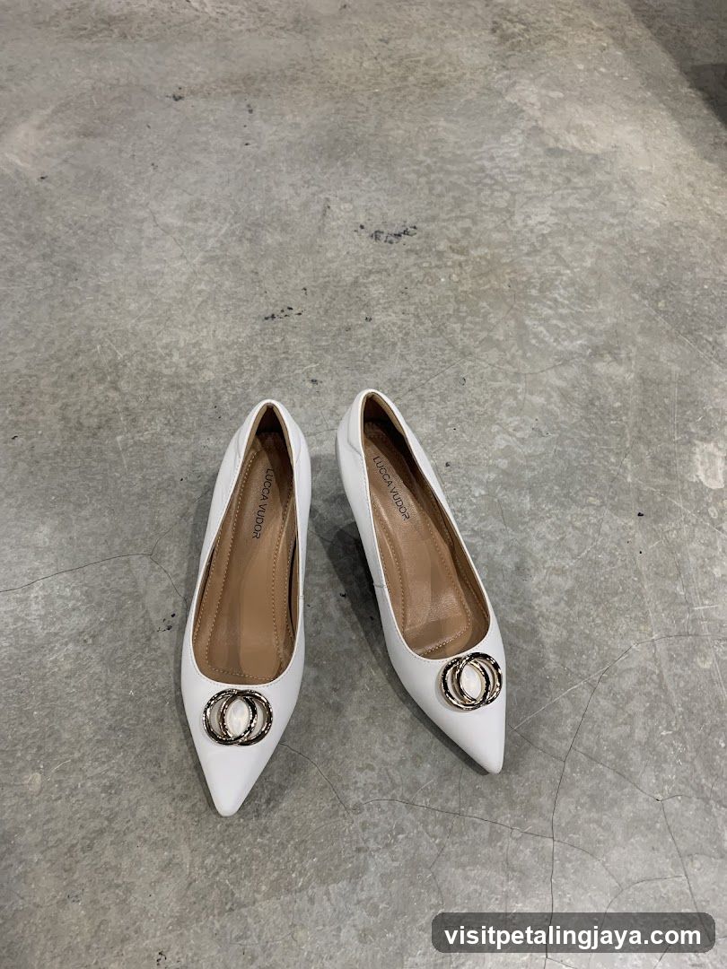 White pointed-toe pumps with decorative rings