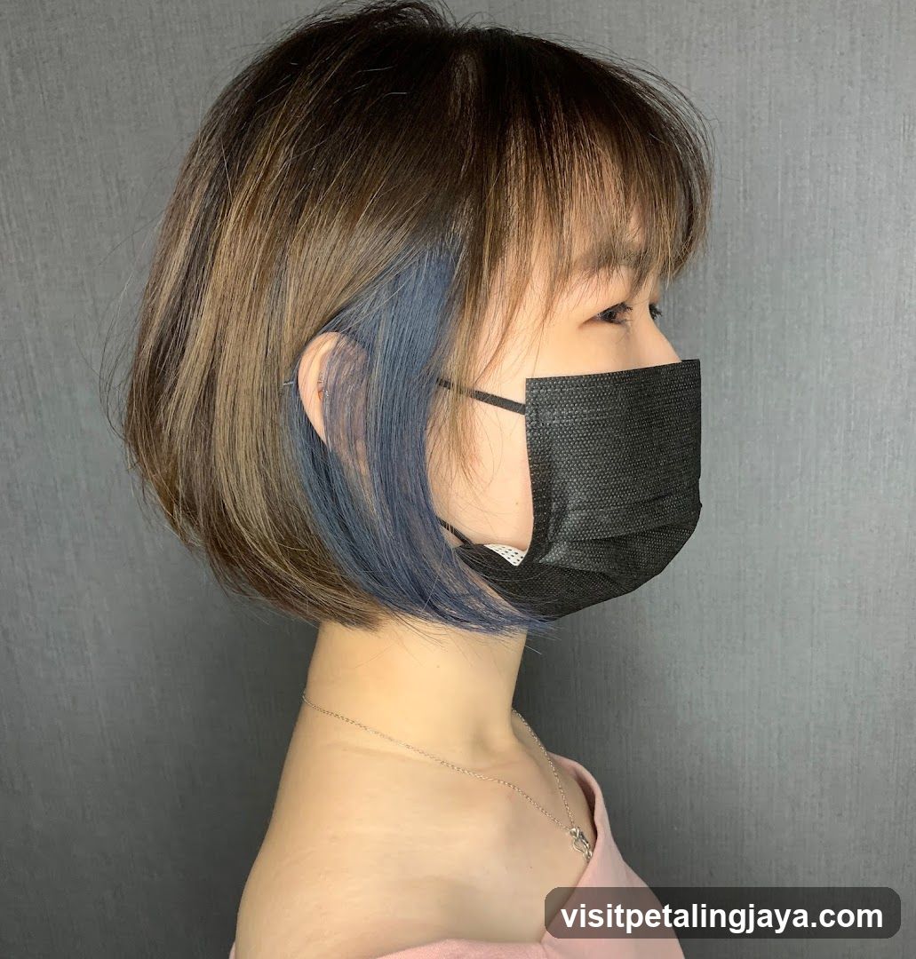 Side profile of person with short hair and blue accent