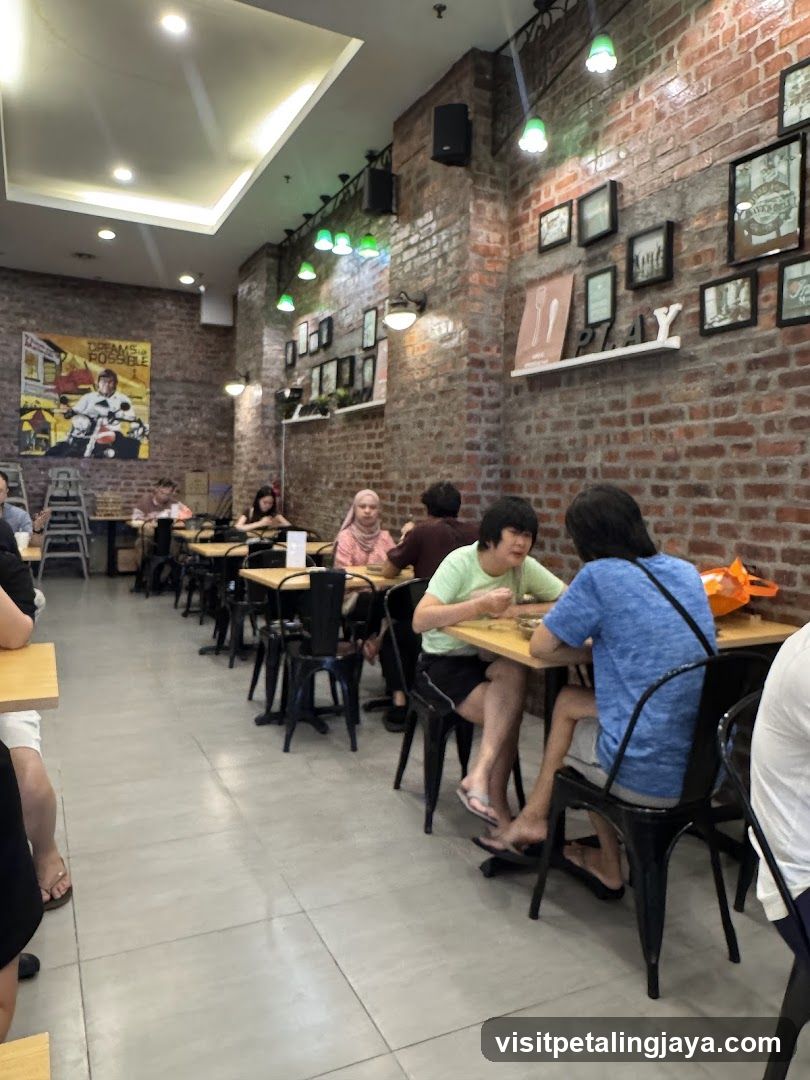 Interior of a casual dining space with brick walls and patrons at tables.