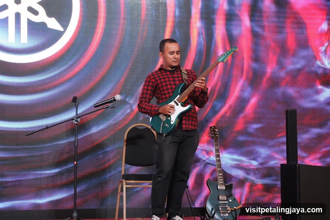 Guitarist on Stage with Yamaha Logo Background