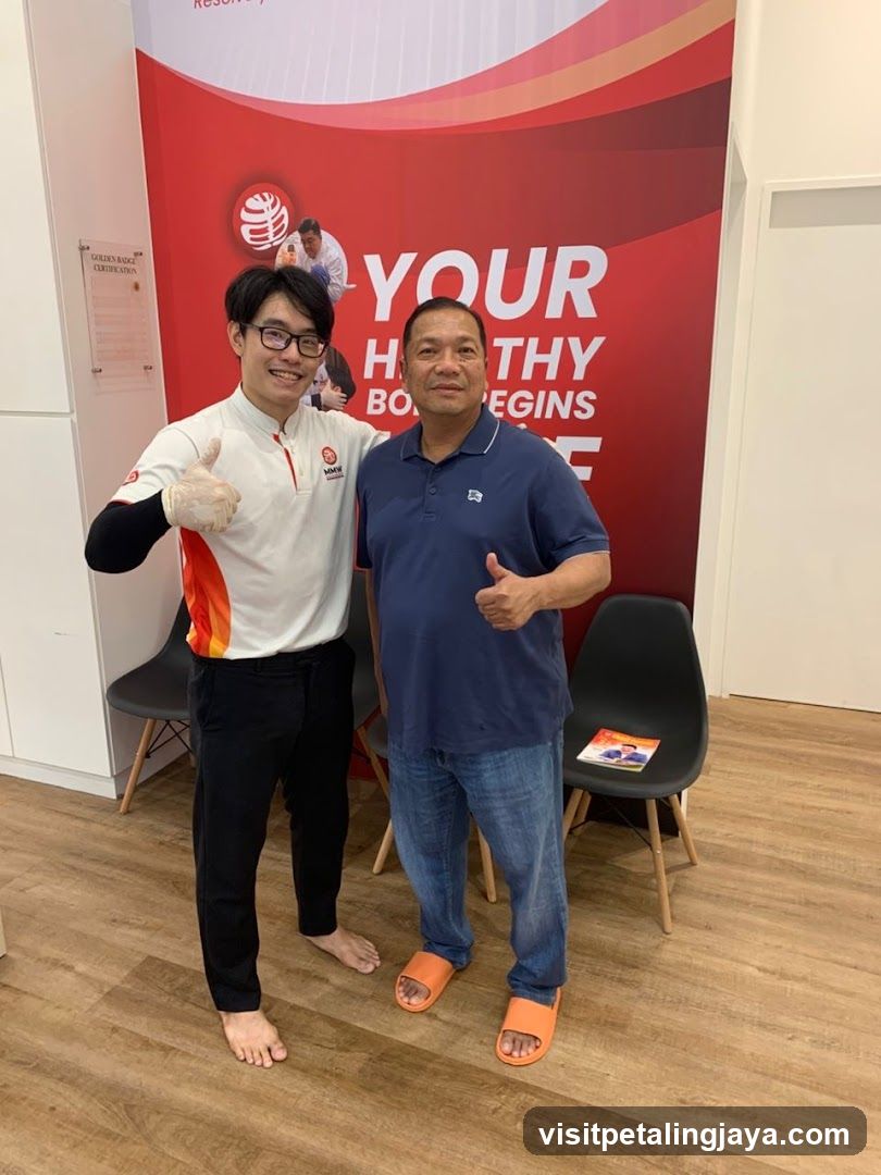 Two men giving thumbs up in front of a health promotion banner