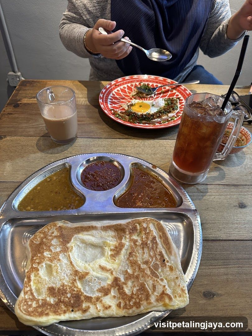 Breakfast Meal with Roti Canai and Side Dishes