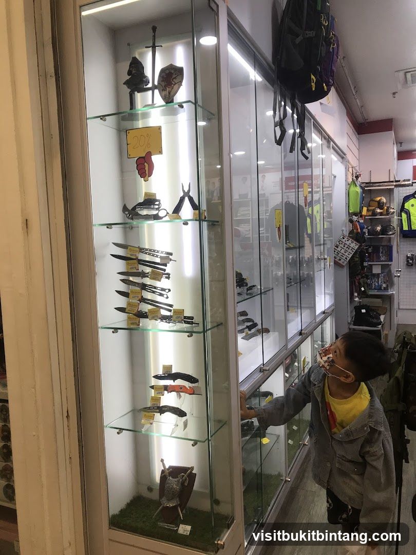 Display case with knives and a child looking