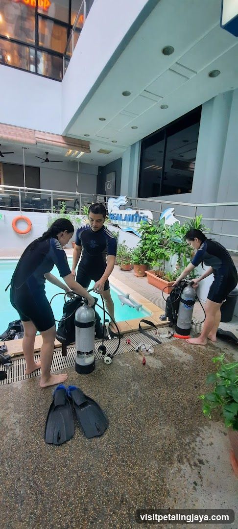 Divers preparing gear by pool