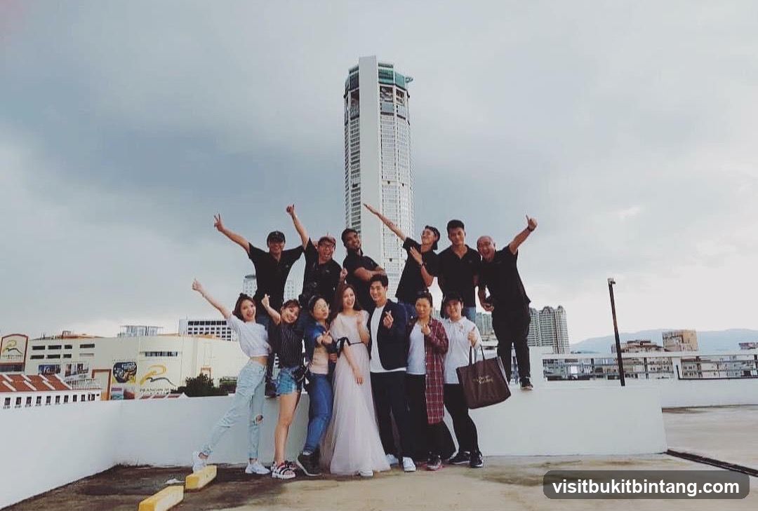 Group posing on rooftop with cityscape