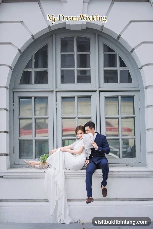 Couple Posing in Front of Large Window