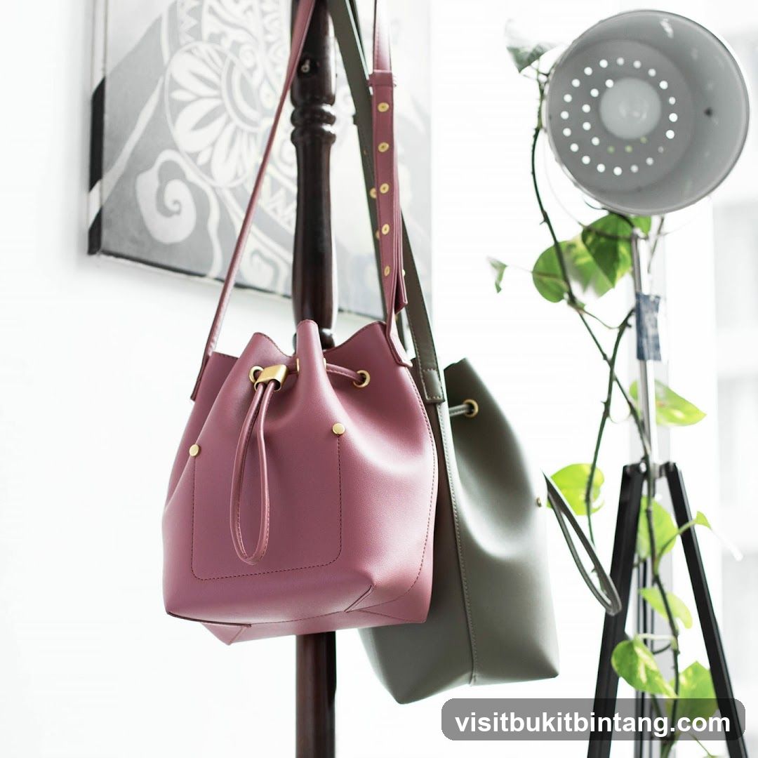 Two bucket bags hanging on a rack
