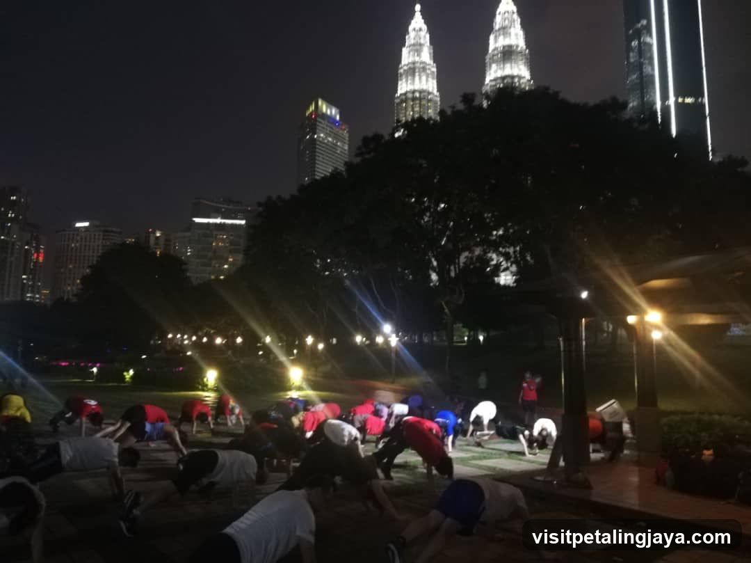 Nighttime Group Exercise in Park with Petronas Twin Towers Background