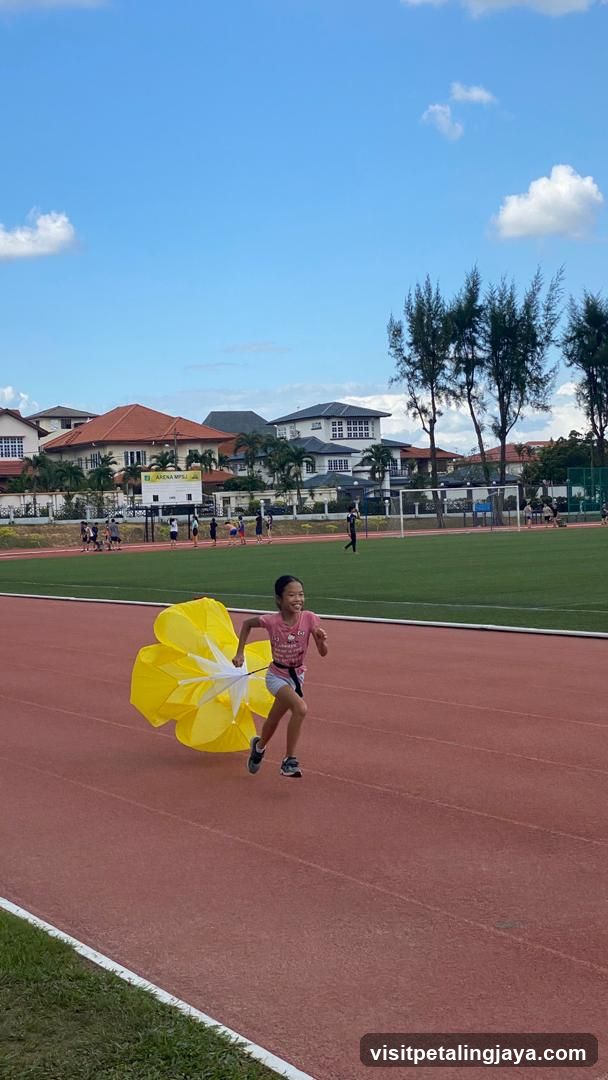 Child Running with Yellow Umbrella on Track