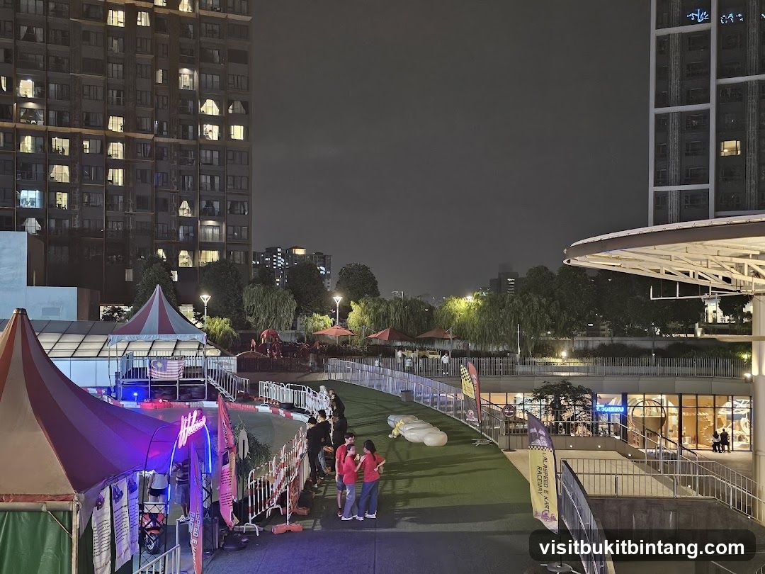 Nighttime outdoor entertainment area with tents and buildings
