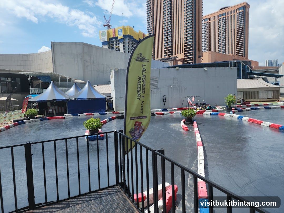 Go-kart track with tents and buildings in the background