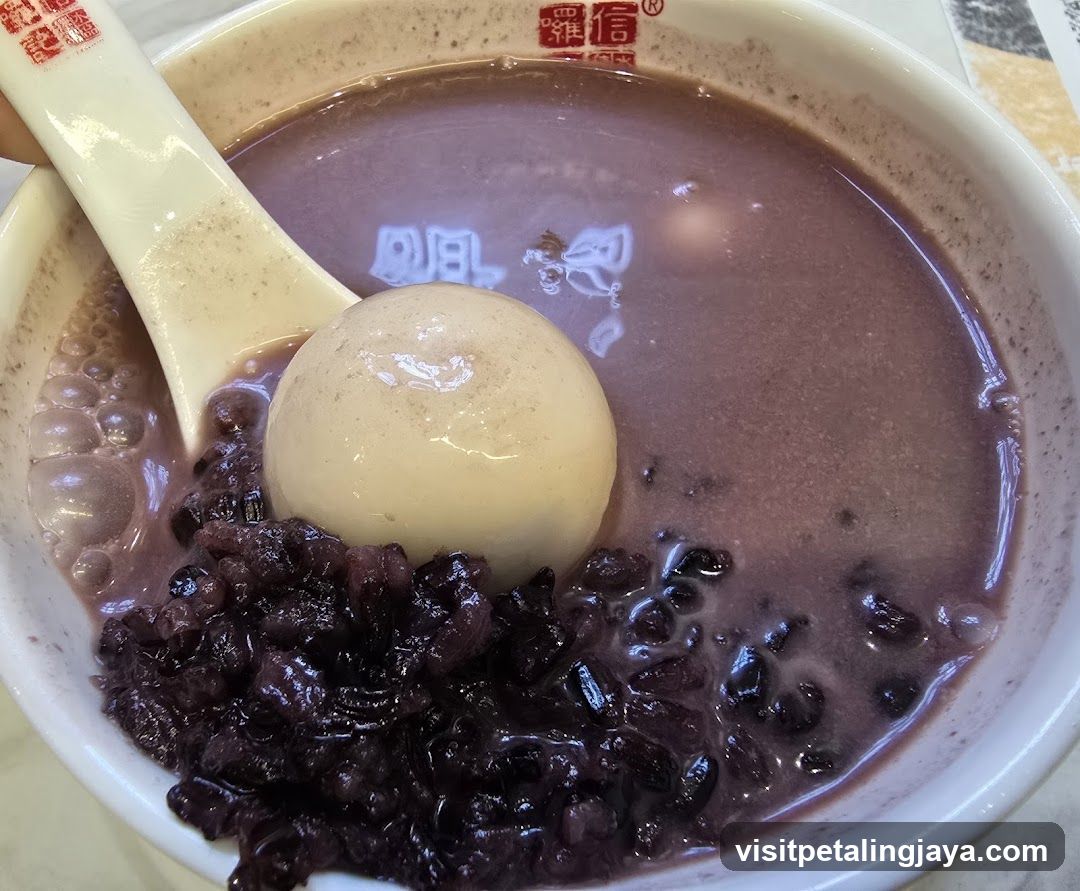 Bowl of purple sweet soup with rice balls and black beans