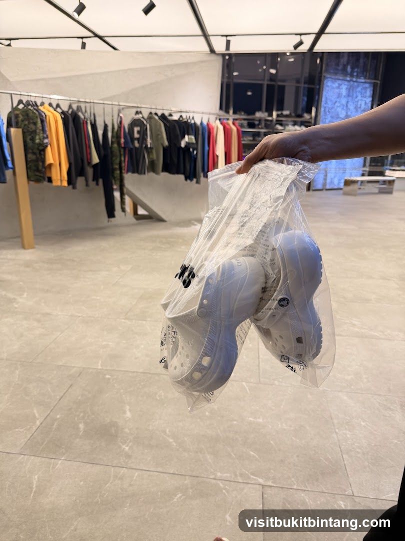 Person holding a bag of white Crocs