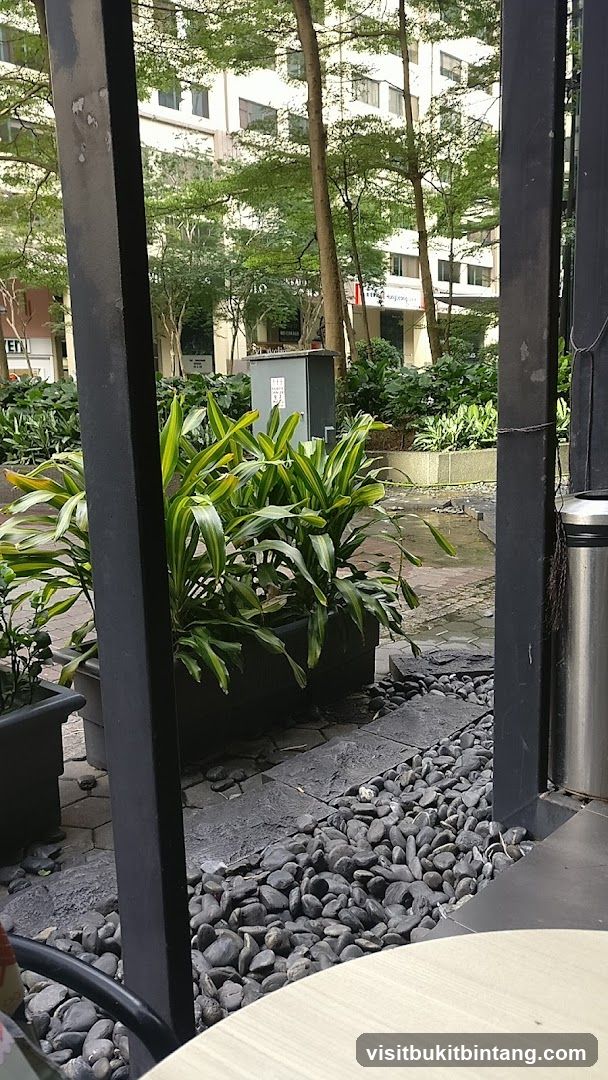Outdoor seating area with plants and buildings in background