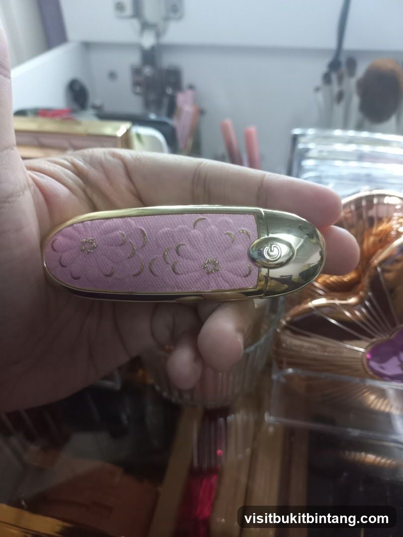 Hand holding a pink and gold lipstick case