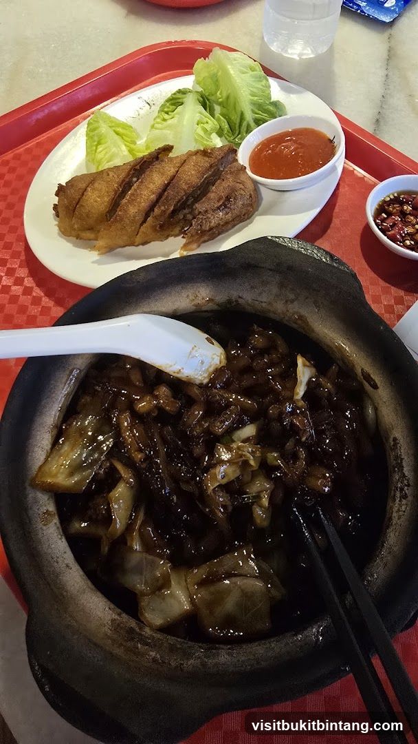 Claypot dish with fried item and dipping sauces