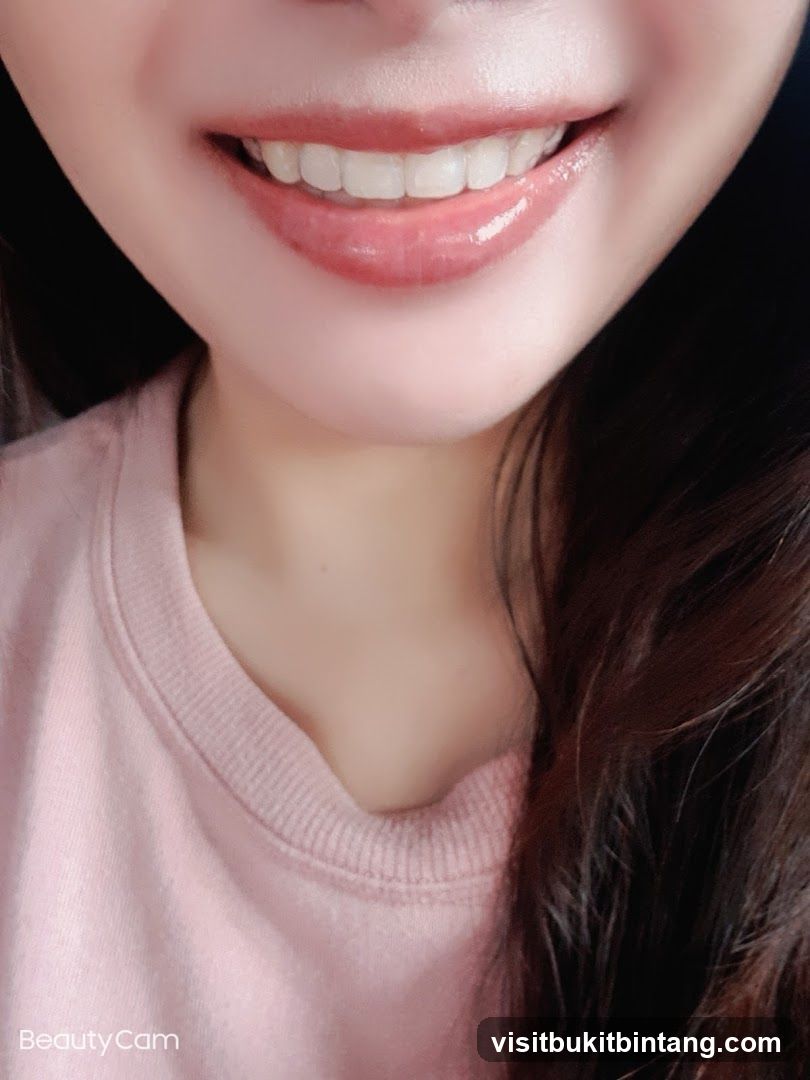 Close-up of a smiling mouth with glossy lips