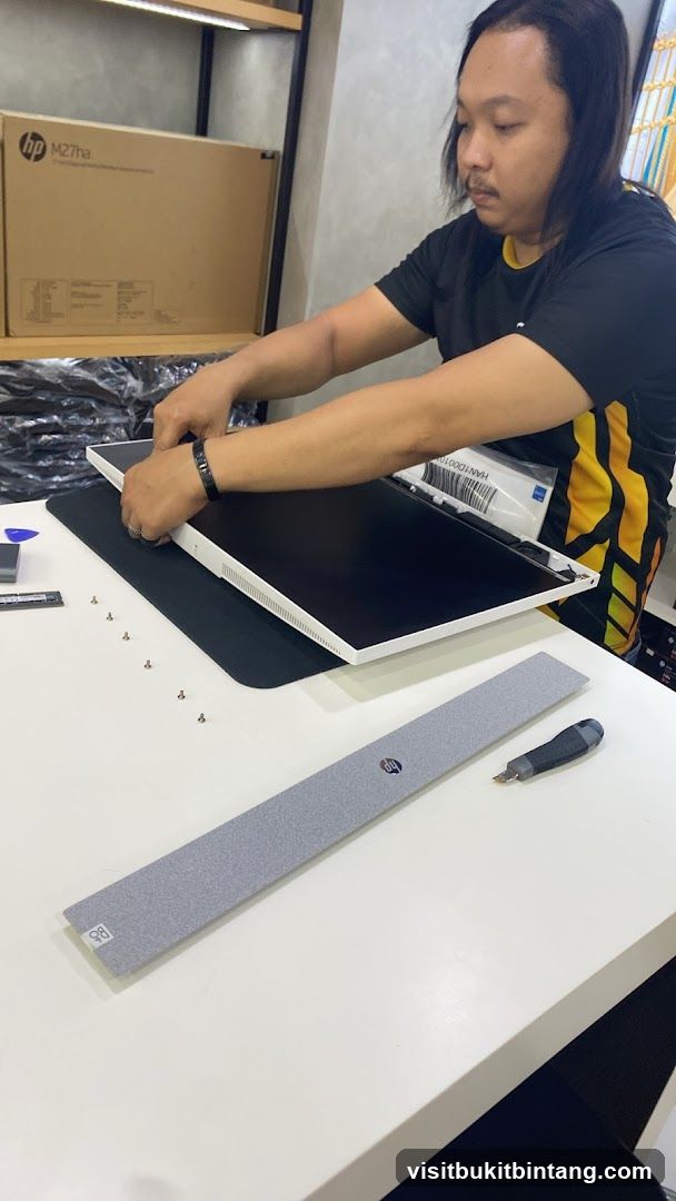 Technician assembling a computer monitor