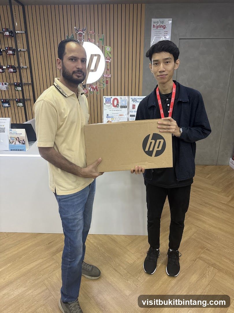 Two men holding a laptop box