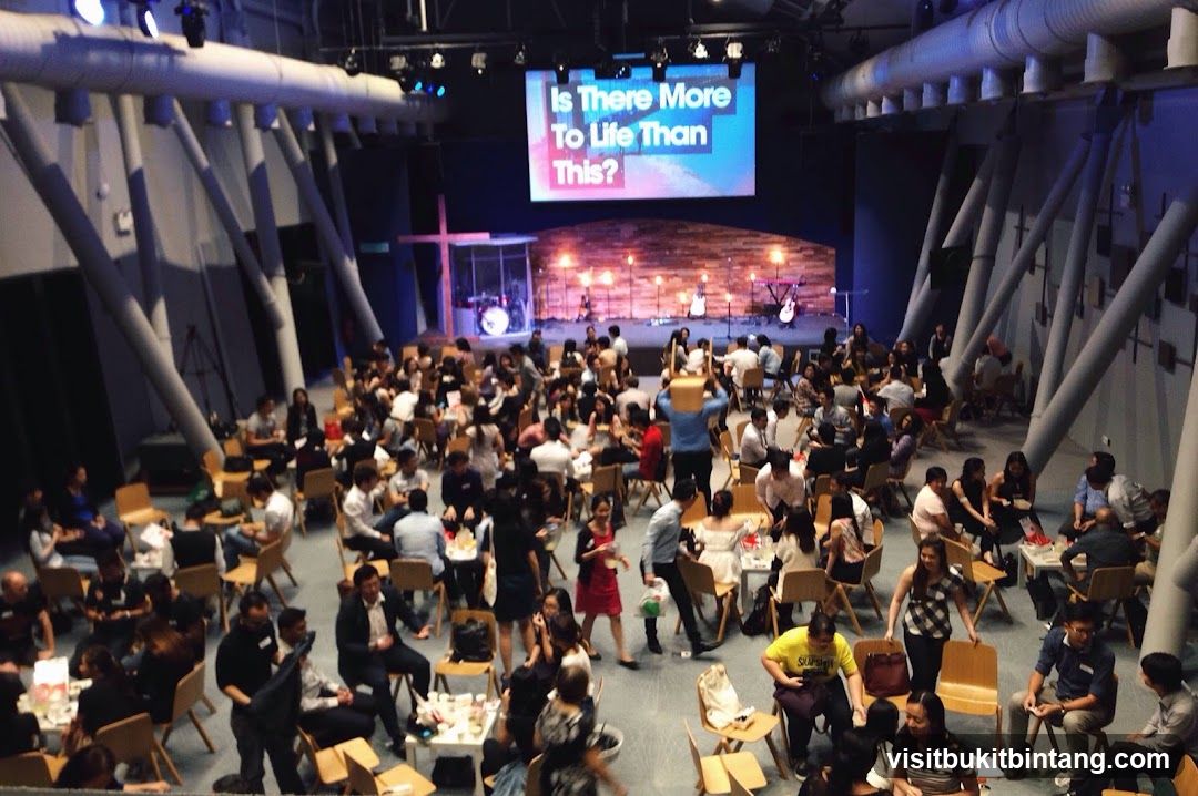 People gathered in a large hall with a stage