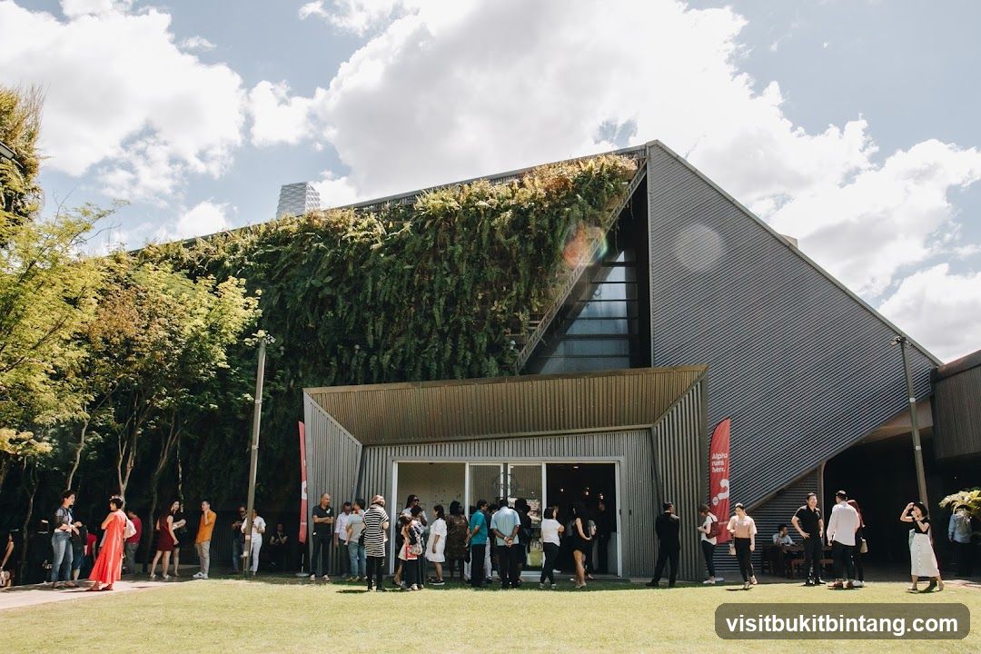 People gathered outside a modern building with a living wall
