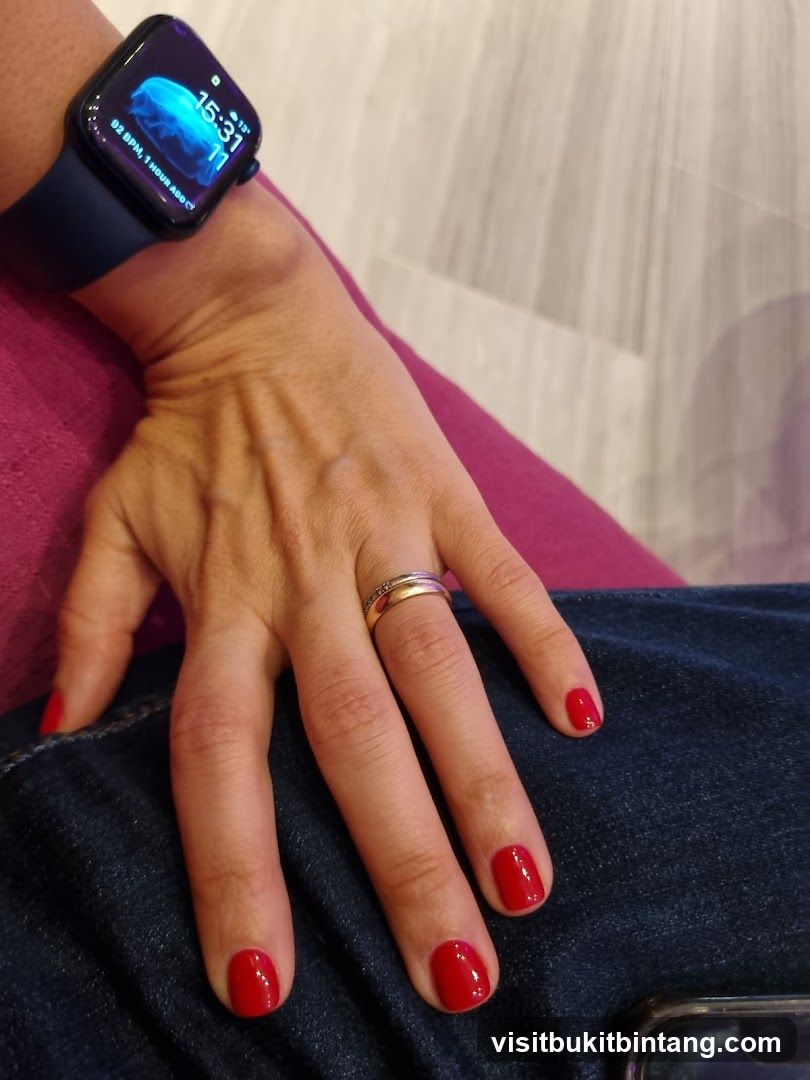 Woman's hand with red nail polish and smartwatch