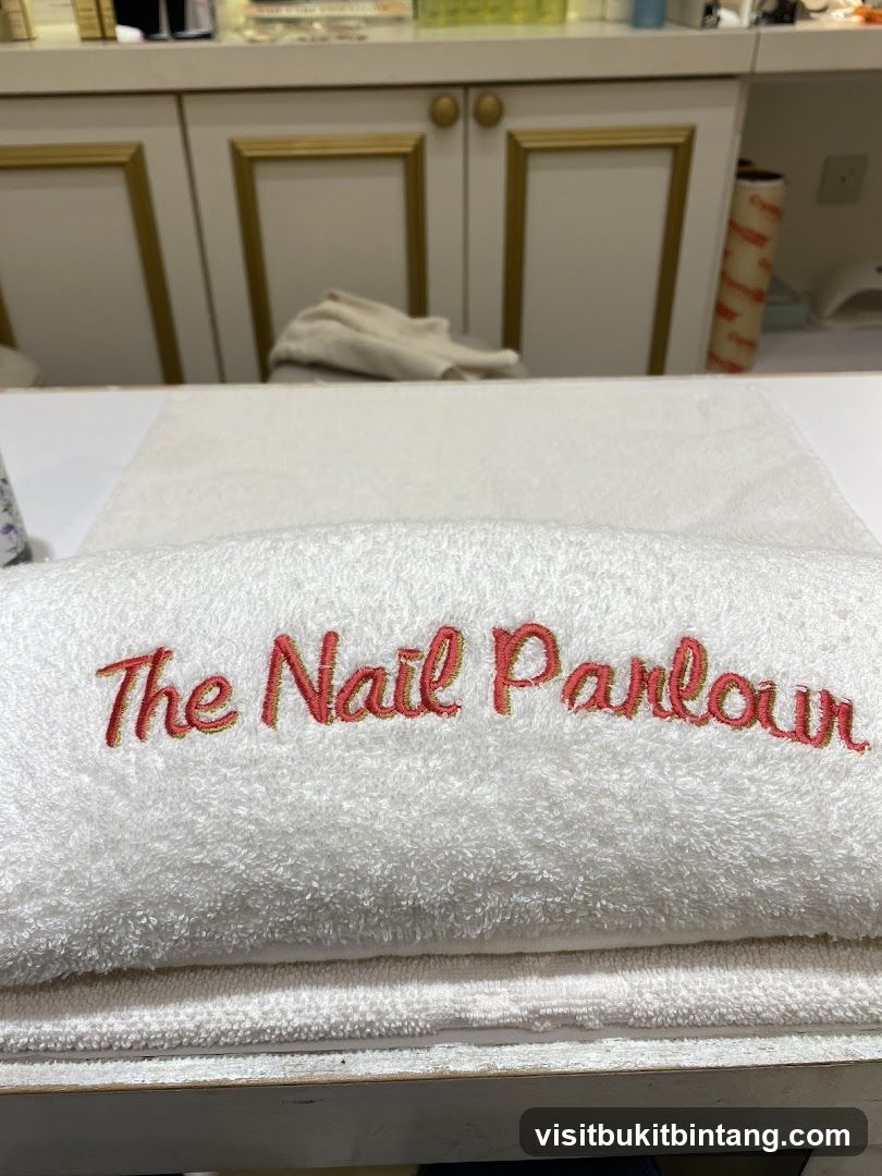 Towel with "The Nail Parlour" embroidered