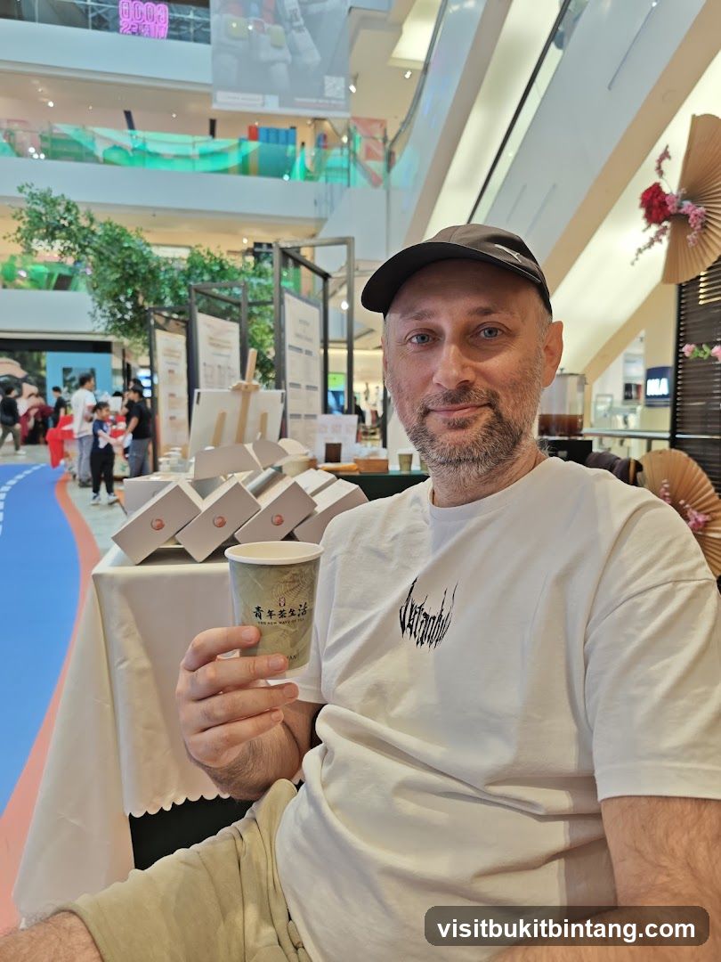 Man holding a cup in a mall