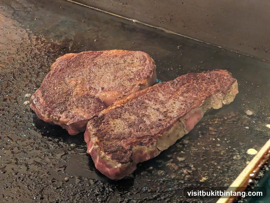 Two steaks cooking on a griddle