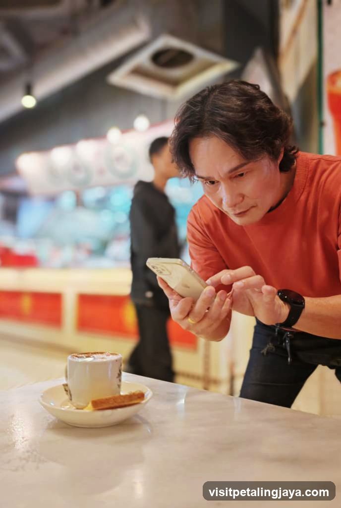 Man Checking Phone at Cafe Table
