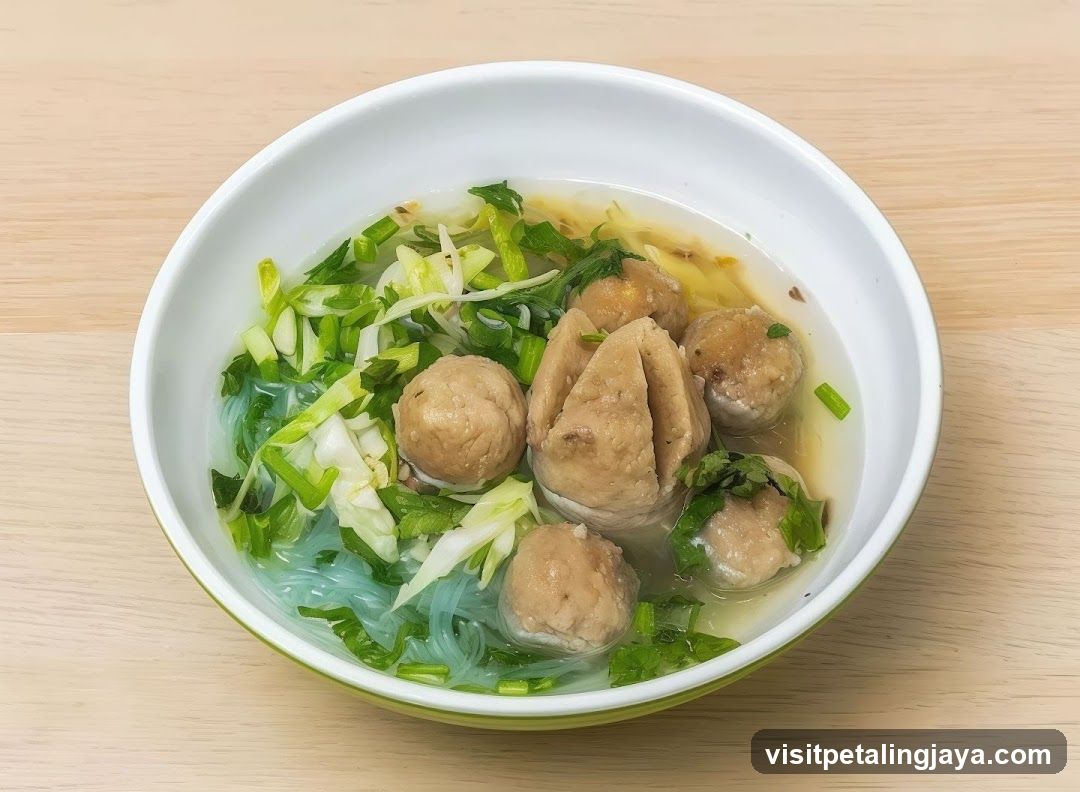 Bowl of Noodle Soup with Meatballs and Greens