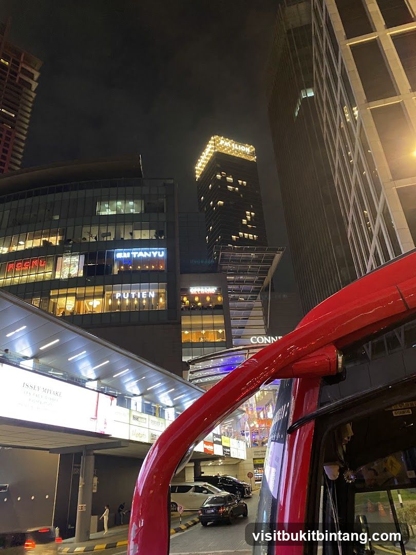 Nighttime cityscape with illuminated buildings and a red vehicle