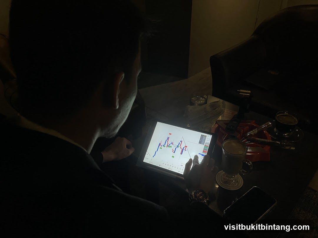 Man analyzing stock market charts on a tablet