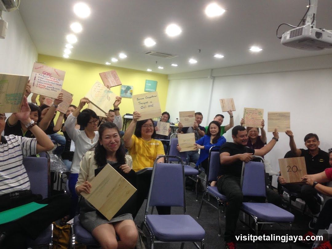 Group holding wooden signs in a meeting room
