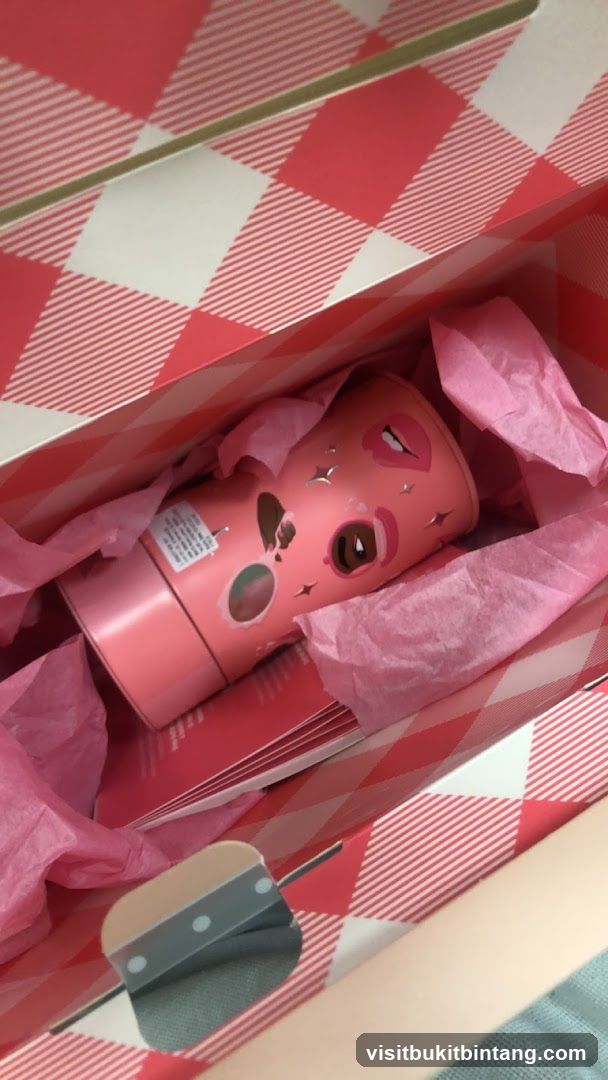 Pink cosmetic bottle in gift bag