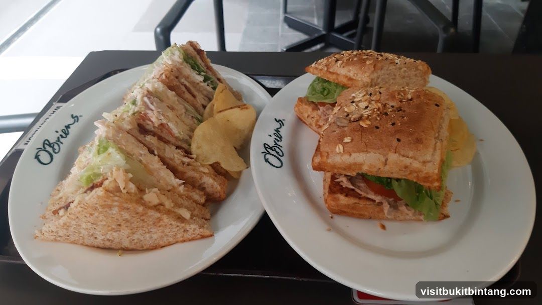 Two plates of sandwiches with potato chips