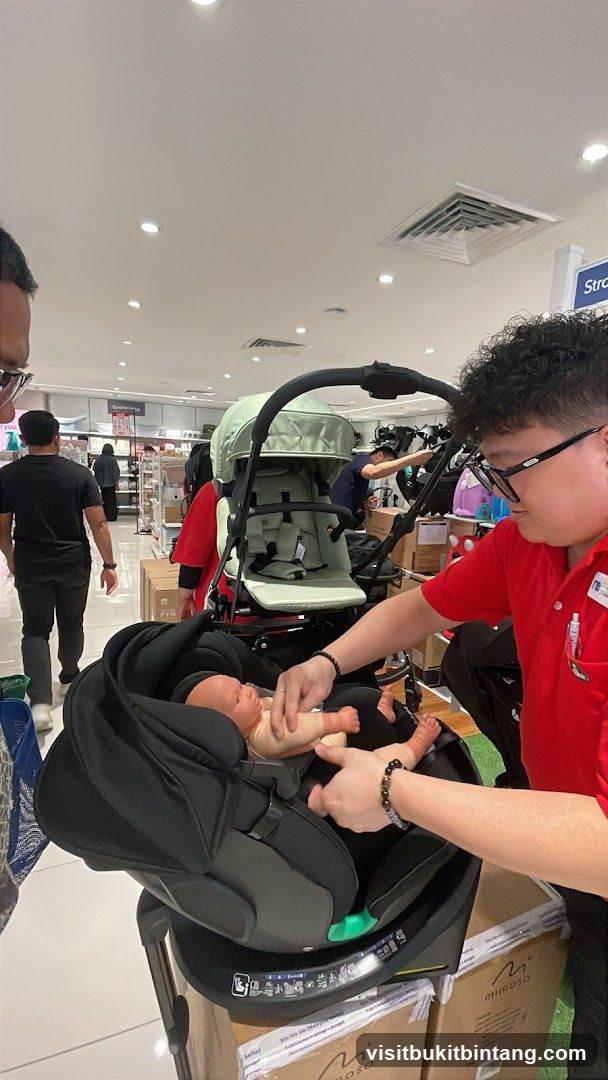 Staff demonstrating a car seat and stroller