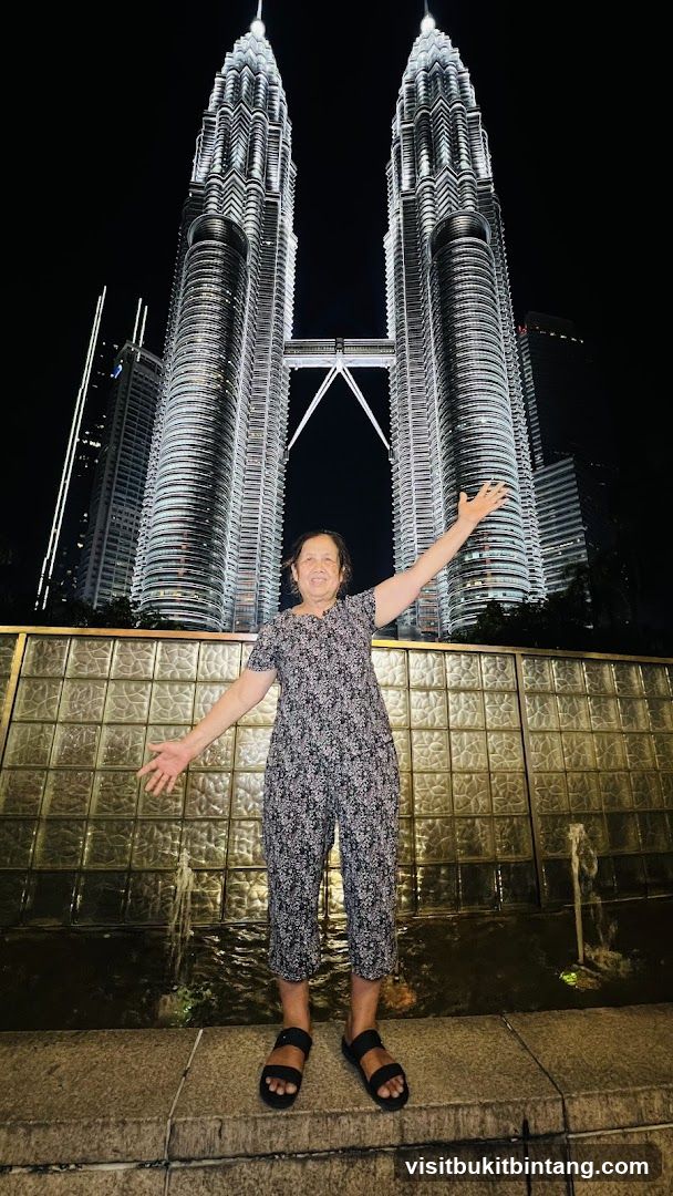 Woman Posing in Front of Petronas Towers at Night
