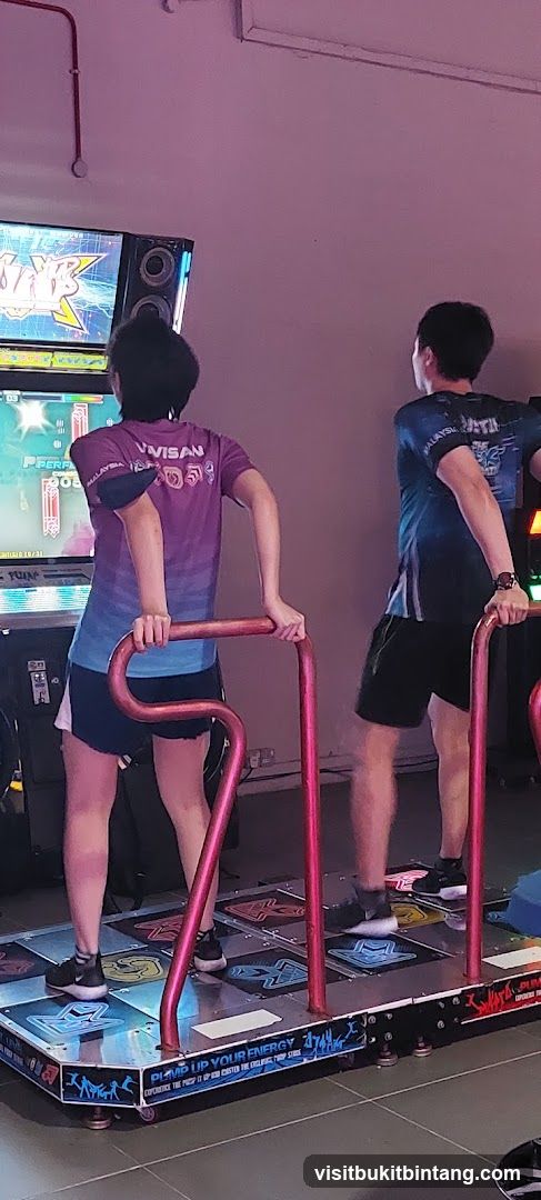 People playing a dance arcade game