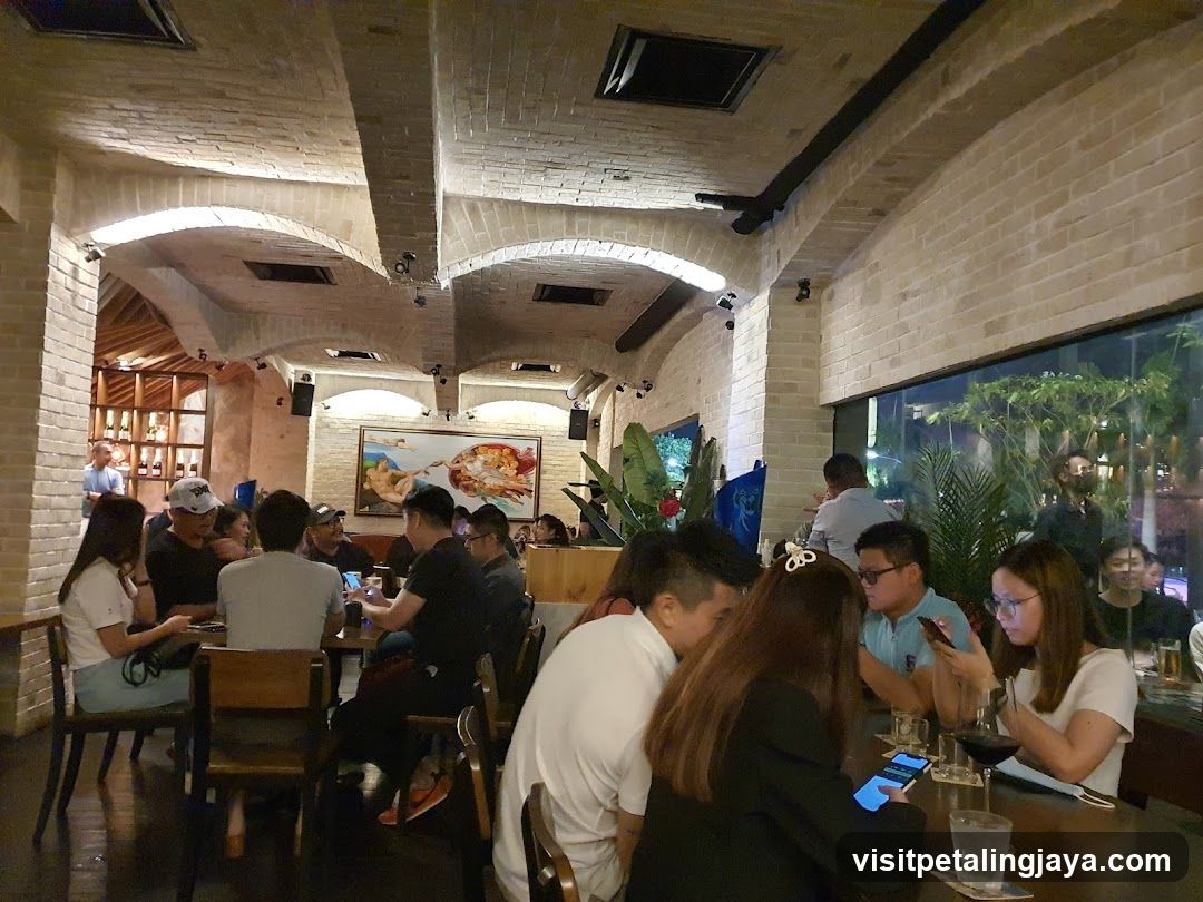 Interior of a bustling restaurant or bar with brick arches and patrons dining at tables.