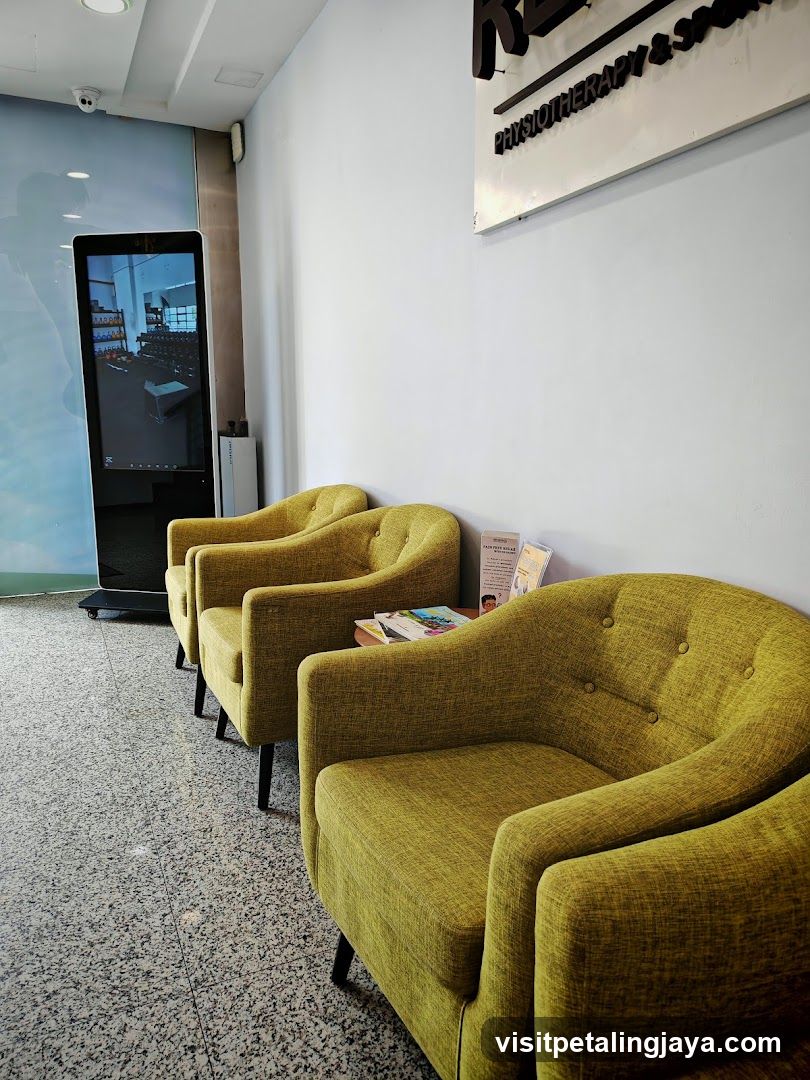Lounge Area with Green Armchairs and Digital Screen