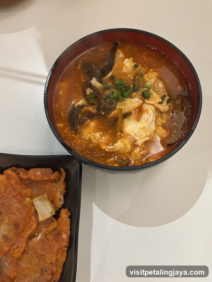 Bowl of Soup with Egg and Side Dish