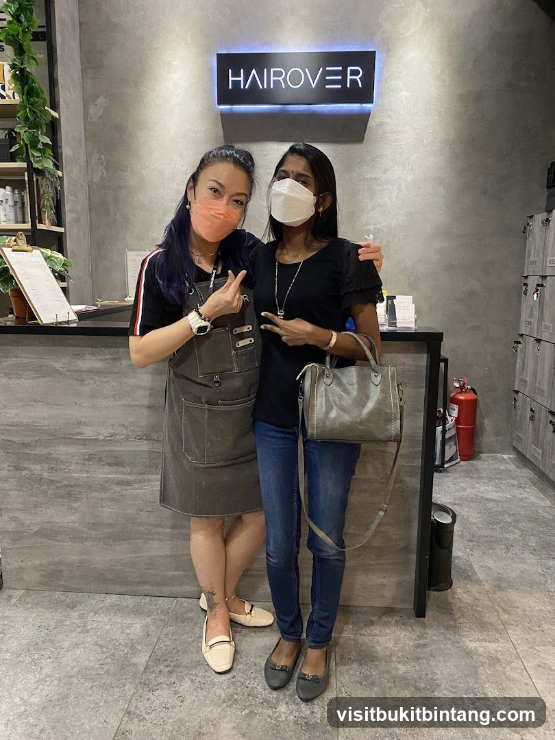 Two women posing in front of a salon sign