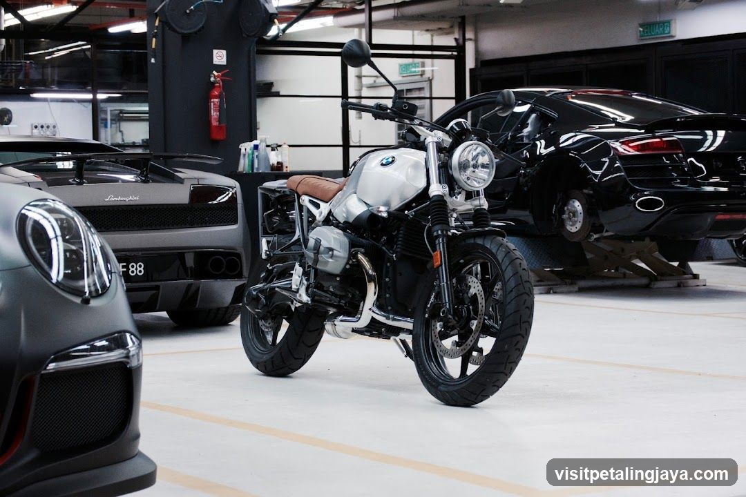 Motorcycle in a garage with luxury cars